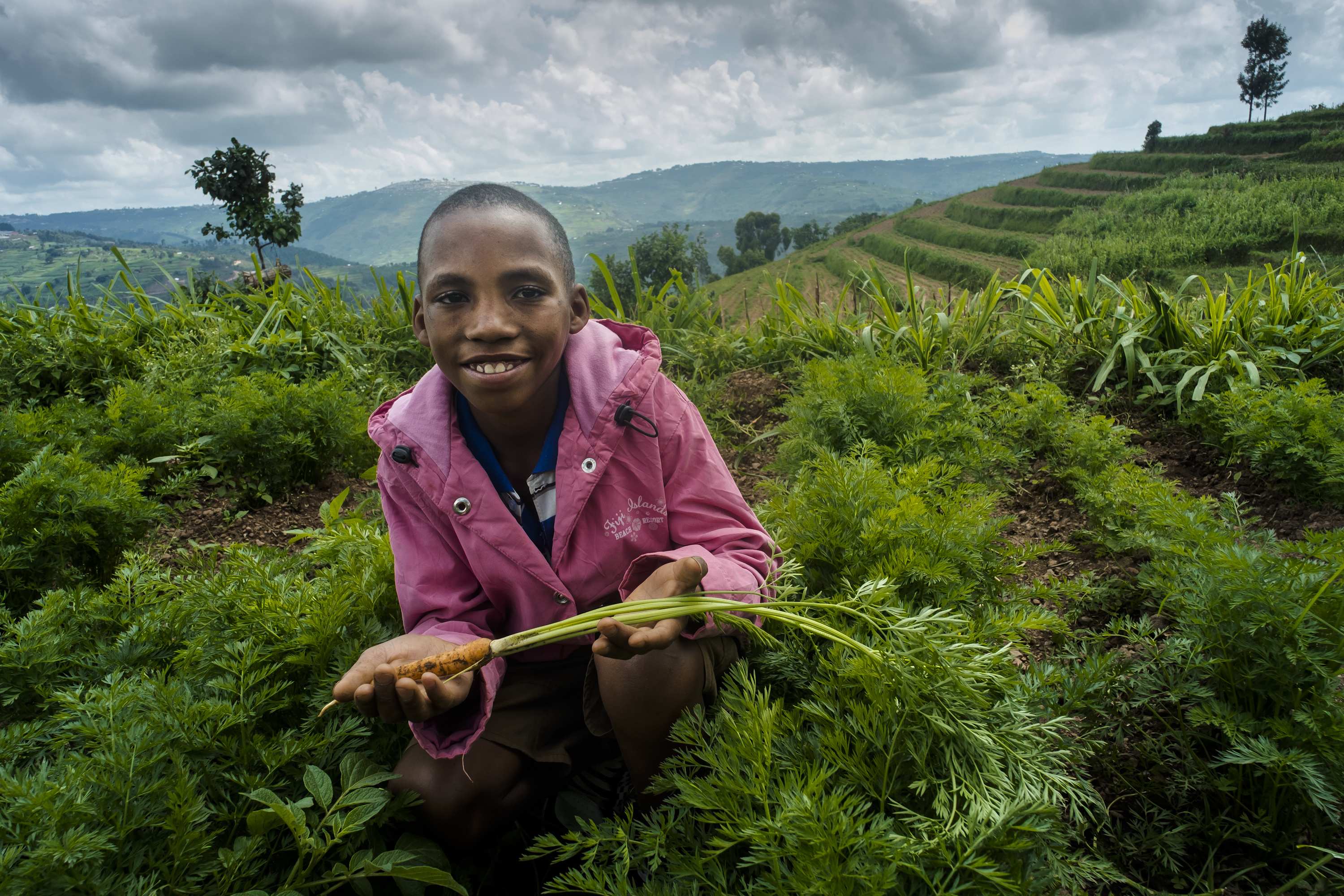 Kind in Ruanda mit einer Karotte (Foto: Jakob Studnar)v