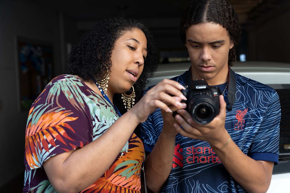 Thais Alvarenga, Sozialarbeiterin bei Promundo und Leiterin des Fotoworkshops mit einem Teilnehmer (Quelle: Christian Nusch) Thais Alvarenga, Sozialarbeiterin bei Promundo und Leiterin des Fotoworkshops mit einem Teilnehmer (Quelle: Christian Nusch)