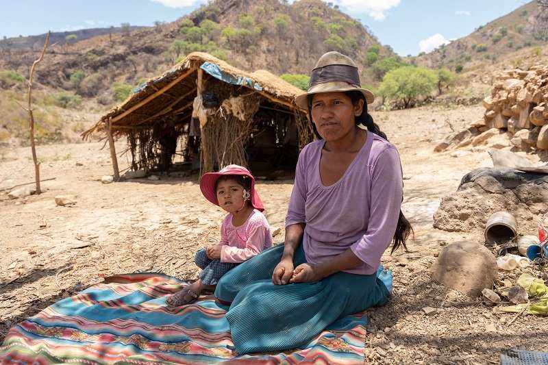 Bolivien: Doña Illary sitzt mit Tochter Wayra (5) vor ihrer ehemaligen Hütte (Quelle: Christian Nusch)
