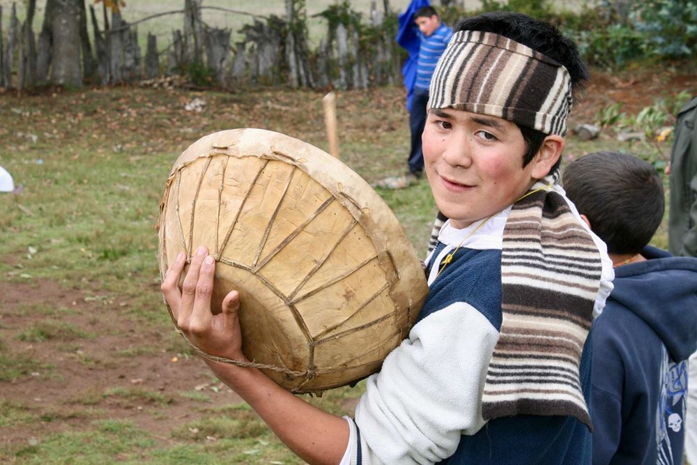 Ein Mapuche-Junge mit der rituellen Schalentrommel Kultrun bei einer Zeremonie in der Schule von Huidima in Südchile - Foto: Jürgen Schübelin