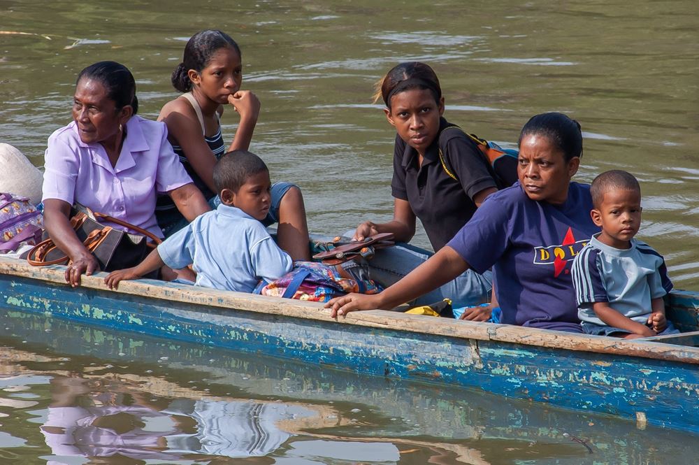 Flüchtlinge überqueren in einem Boot einen Fluss (Quelle: iStock/gonzalobellphoto)