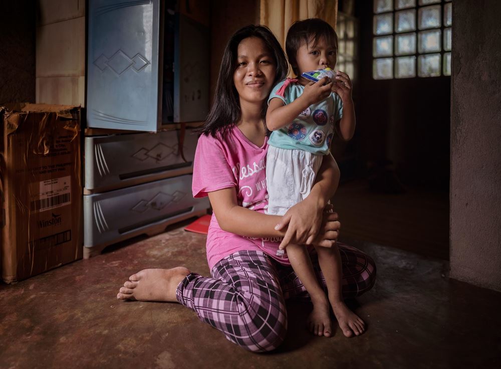 Eine Mutter sitzt auf dem Boden und umarmt ihre kleine Tochter, die vor ihr steht (Quelle: Jakob Studnar)