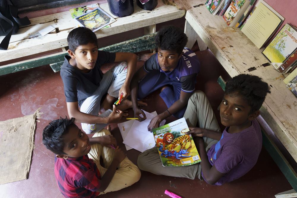 Vier Jungen sitzen in einer Leseecke auf dem Boden (Quelle: Christian Nusch) Die Leseecke in der Bibliothek ist sehr beliebt (Foto: Christian Nusch)