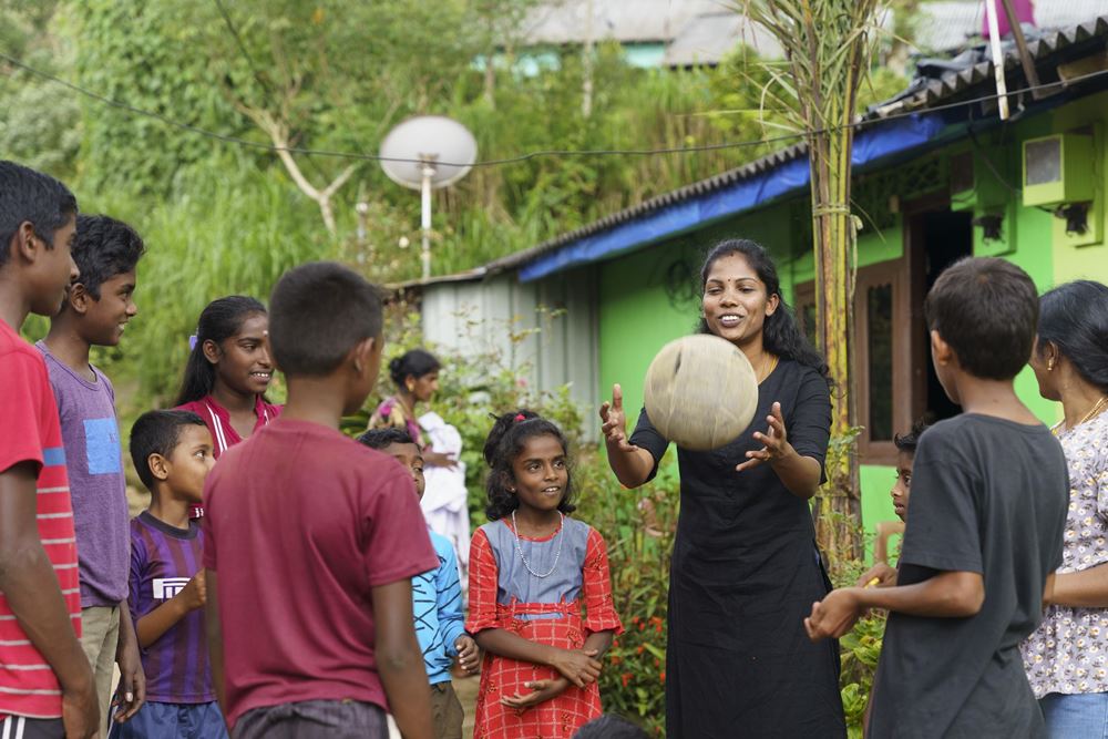 Eine Mitarbeiterin eines Kindernothilfepartners spielt mit Kindern Ball (Quelle: Christian Nusch) TLV-Mitarbeiterin Aruniya ist sehr zuversichtlich, was die Zukunft der Kinder und Familien in dieser Siedlung angeht (Foto: Christian Nusch)