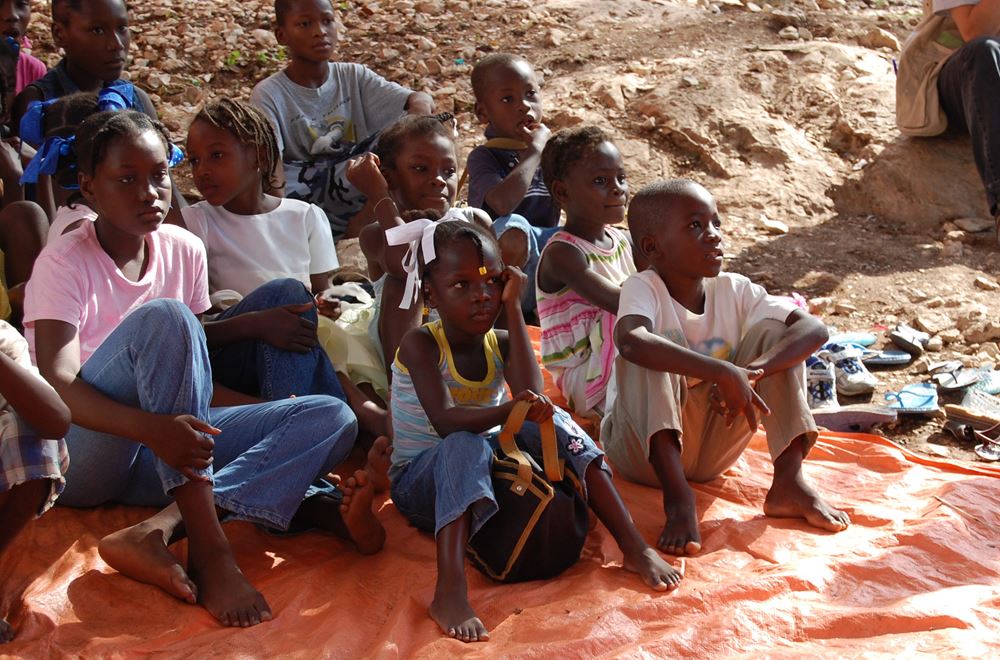 Mädchen und Jungen aus Haiti sitzen auf dem Foto. Fast die Hälfte der knapp drei Millionen Mädchen und Jungen leidet unter akutem Hunger. Schulen sind geschlossen und die Gewalt gegen Kinder nimmt verheerende Ausmaße an. (Foto: Erhard Stückrath/Kindernothilfe) Mädchen und Jungen aus Haiti sitzen auf dem Foto. Fast die Hälfte der knapp drei Millionen Mädchen und Jungen leidet unter akutem Hunger. Schulen sind geschlossen und die Gewalt gegen Kinder nimmt verheerende Ausmaße an. (Foto: Erhard Stückrath/Kindernothilfe)
