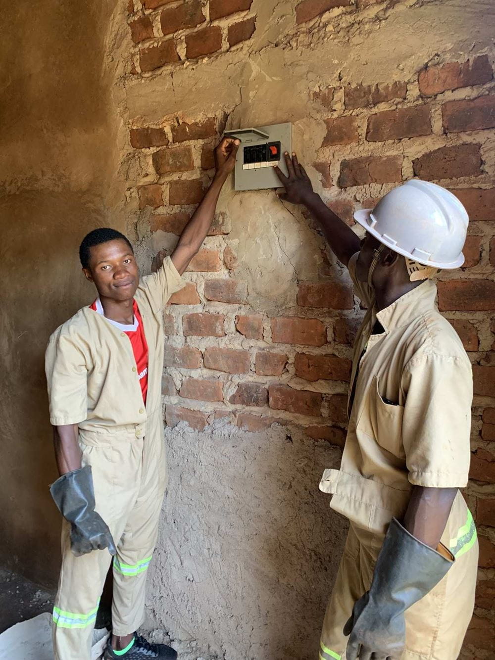 CBT Ex-Trainees zeigen ein Haus, das sie verkabelt haben (Foto: Andreas Wagner) CBT Ex-Trainees zeigen ein Haus, das sie verkabelt haben (Foto: Kindernothilfe)