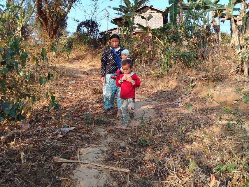 Eine Mutter mit zwei Kindern auf einem Trampelpfad hinab von einem Hügel (Quelle: Kindernothilfepartner) Eine Mutter mit zwei Kindern auf einem Trampelpfad hinab von einem Hügel (Quelle: Kindernothilfepartner)