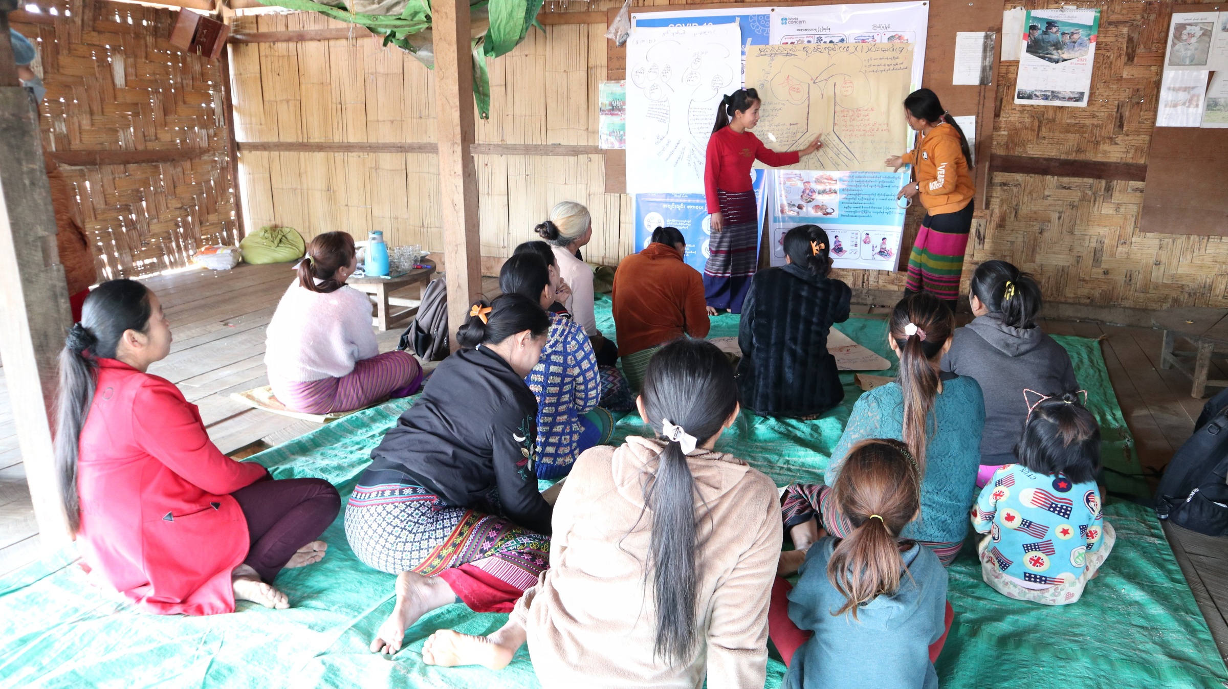 Frauen und Kinder sitzen auf dem Boden vor einer Tafel, an der zwei Frauen etwas erklären (Quelle: Kindernothilfepartner) Frauen und Kinder sitzen auf dem Boden vor einer Tafel, an der zwei Frauen etwas erklären (Quelle: Kindernothilfepartner)
