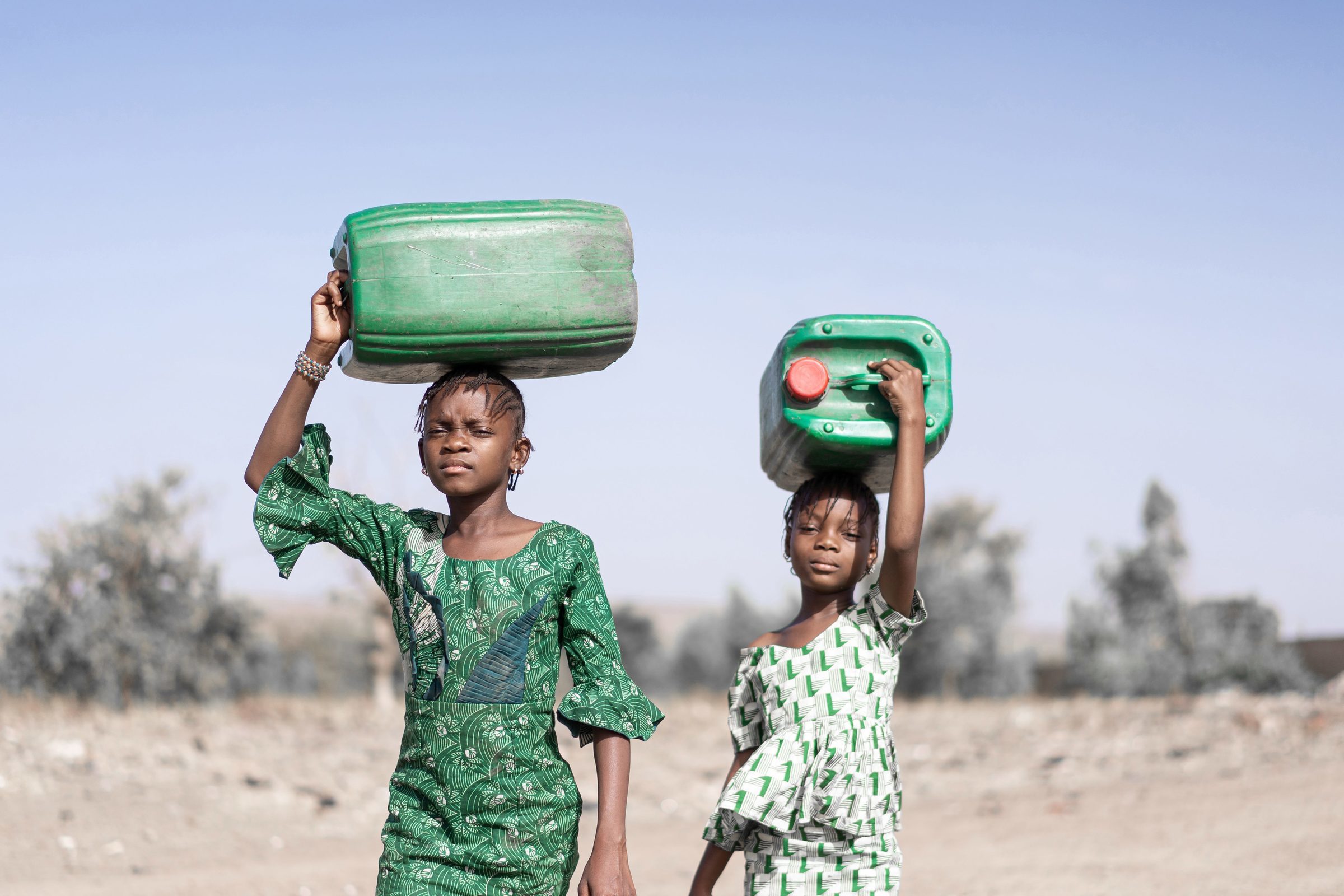 Mädchen tragen Wasserkanister. (Foto: Shutterstock) Mädchen tragen Wasserkanister. (Foto: Shutterstock)