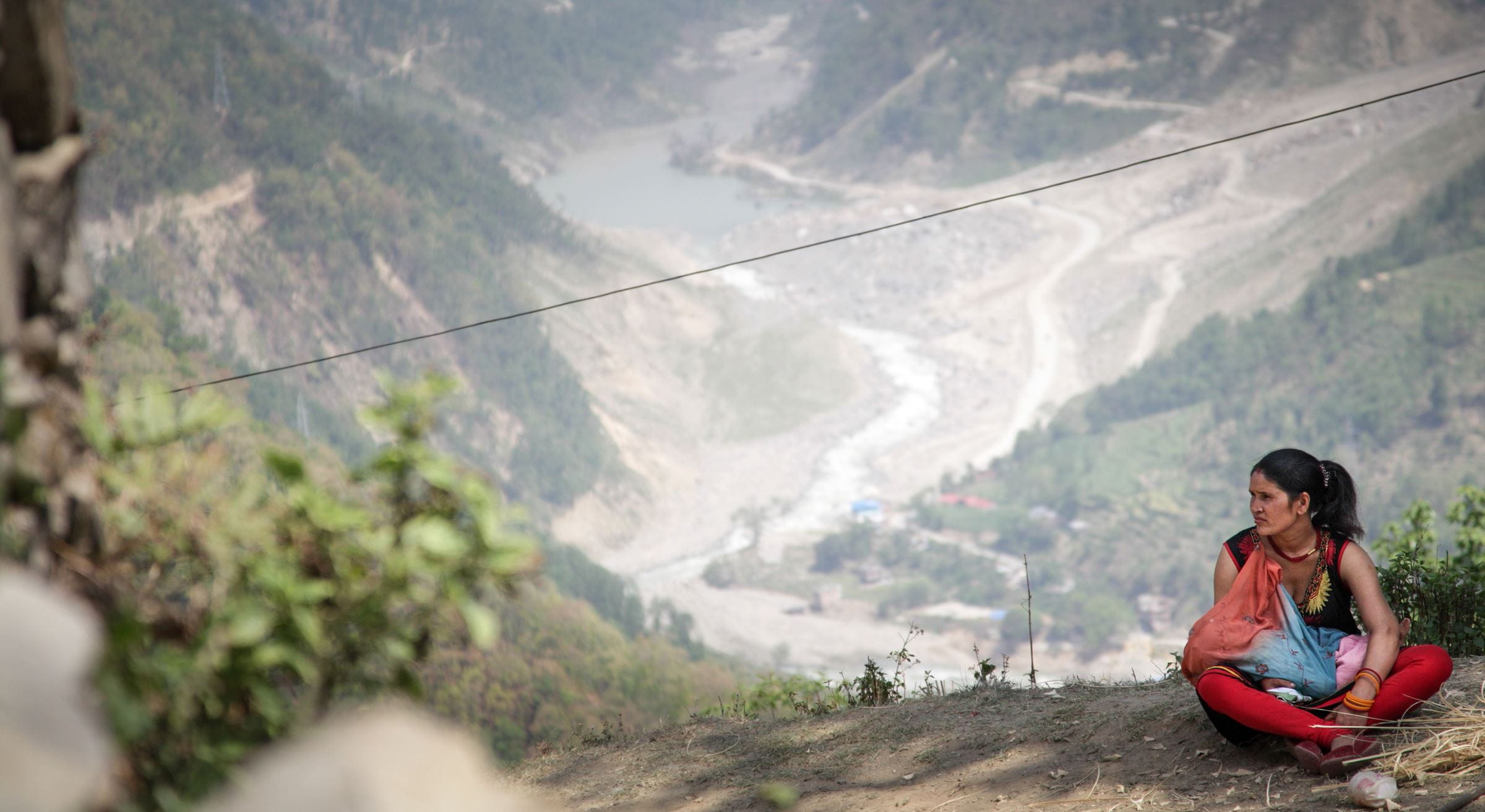 Symbolfoto Nepal: Eine Frau sitzt auf dem Boden auf einem Berg. Im Hintergrund ist ein Fluss in einem Tal (Quelle: Bastian Strauch) Symbolfoto Nepal: Eine Frau sitzt auf dem Boden auf einem Berg. Im Hintergrund ist ein Fluss in einem Tal (Quelle: Bastian Strauch)