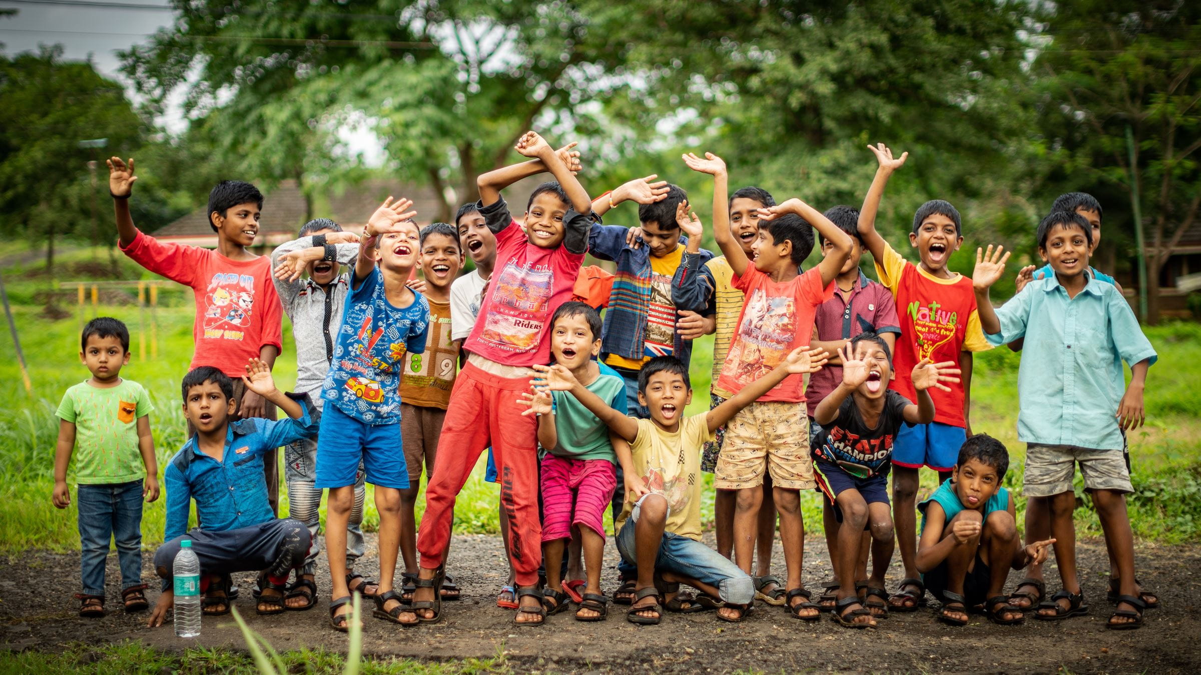 Eine Gruppe aus Jungen winkt in die Kamera - Indien. (Quelle: Jakob Studnar)