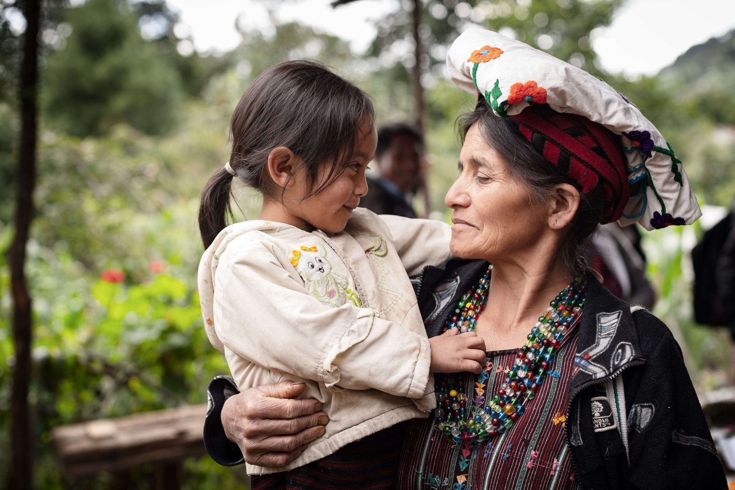 Eine alte Frau hält liebevoll ein Mädchen im Arm. (Quelle: Jakob Studnar)