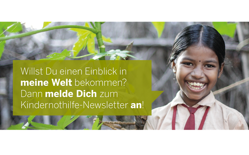 Ein indisches Mädchen steht unter einer Pflanze und lacht in die Kamera. (Quelle: Bastian Strauch) Ein indisches Mädchen steht unter einer Pflanze und lacht in die Kamera. (Quelle: Bastian Strauch)