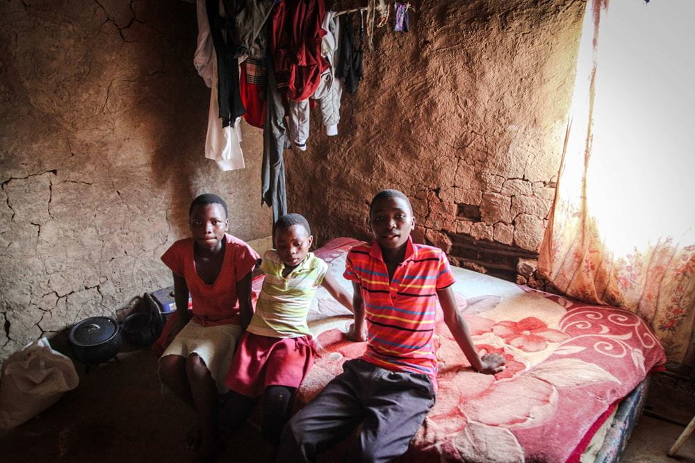 Foto: Drei Jugendliche sitzen auf einem Bett in einer ärmlichen Hütte (Quelle: Ralf Krämer, Kindernothilfe) Foto: Drei Jugendliche sitzen auf einem Bett in einer ärmlichen Hütte (Quelle: Ralf Krämer, Kindernothilfe)