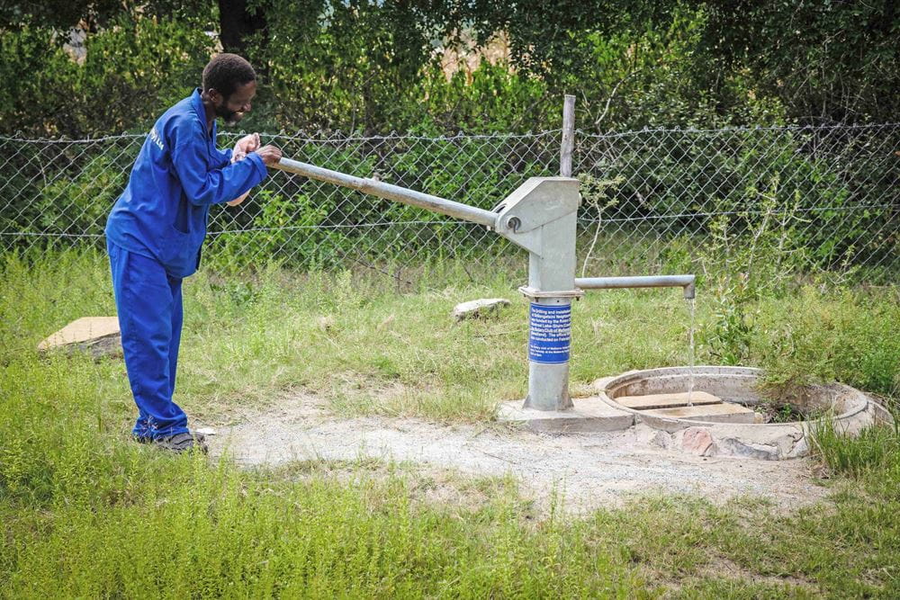 Foto: Ein Landwirtschaftsexperte pumpt Wasser in ein Auffangbecken (Quelle: Ralf Krämer, Kindernothilfe)