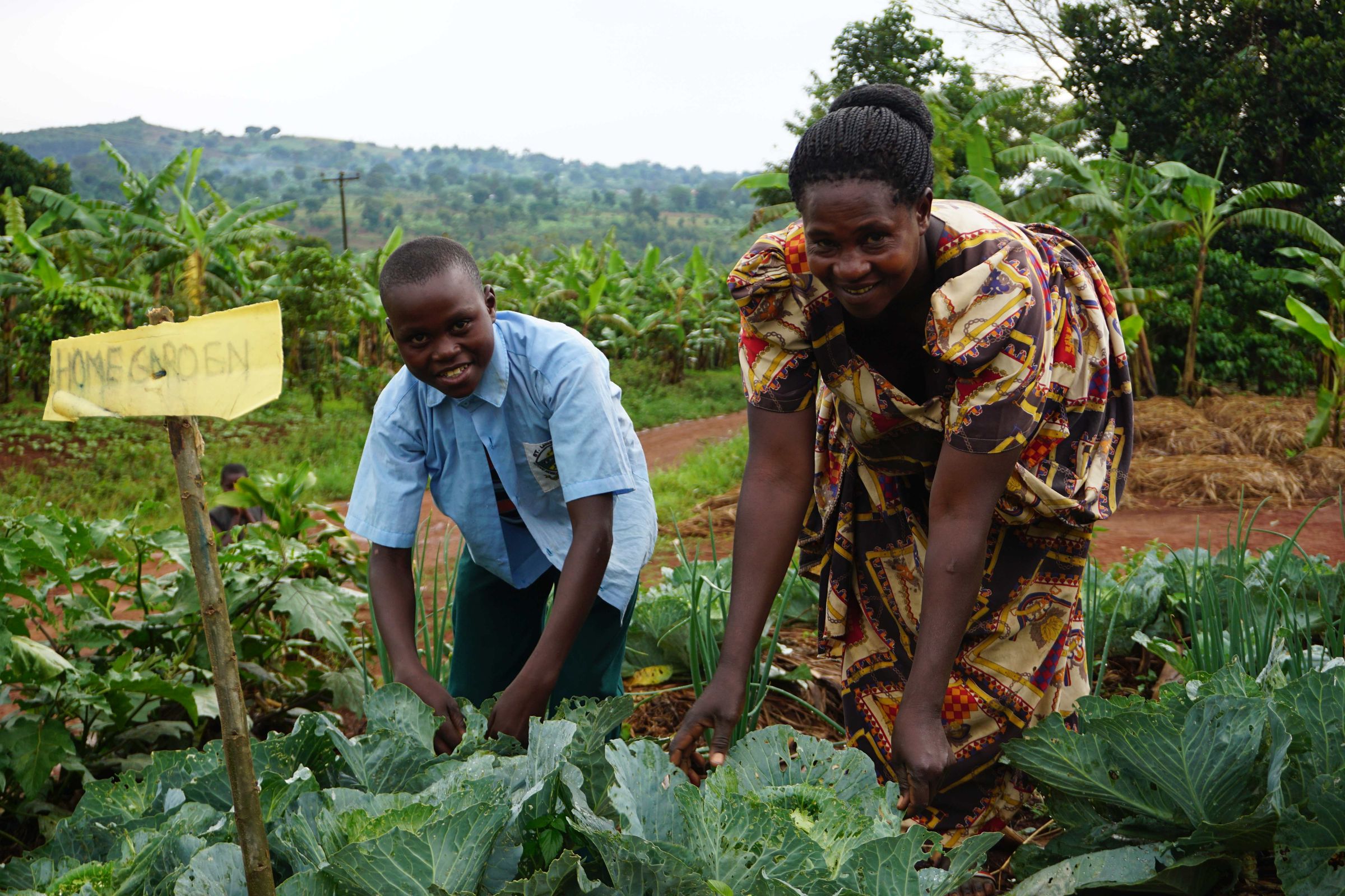 Reportage Uganda: Aufschwung am Äquator; Foto: Zwei Personen bei der Feldarbeit (Quelle: Ludwig Grunewald / Kindernothilfe)