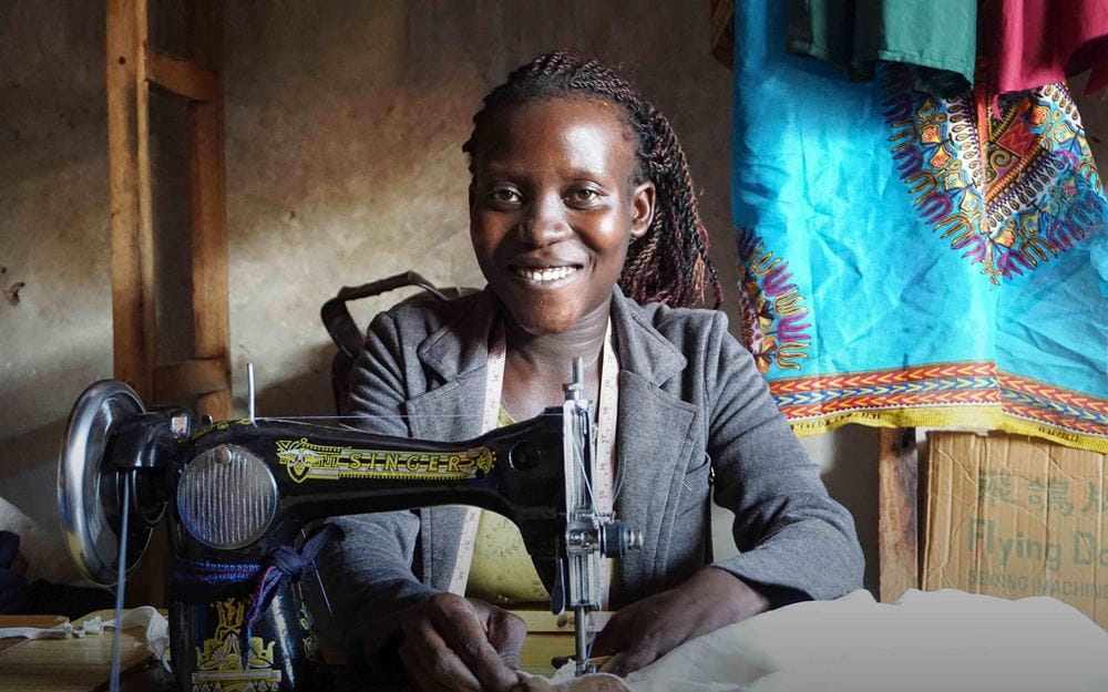 Reportage Uganda: Aufschwung am Äquator; Foto: Frau sitzt an der Nähmaschine (Quelle: Ludwig Grunewald / Kindernothilfe) Reportage Uganda: Aufschwung am Äquator; Foto: Frau sitzt an der Nähmaschine (Quelle: Ludwig Grunewald / Kindernothilfe)